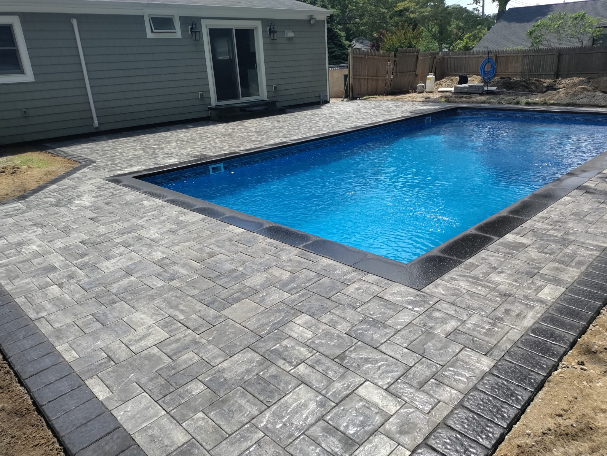 Residential paver patio around a pool installed by JR Masonry Contractor